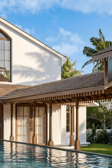 Restored Goan veranda with carved timber columns beside a pool