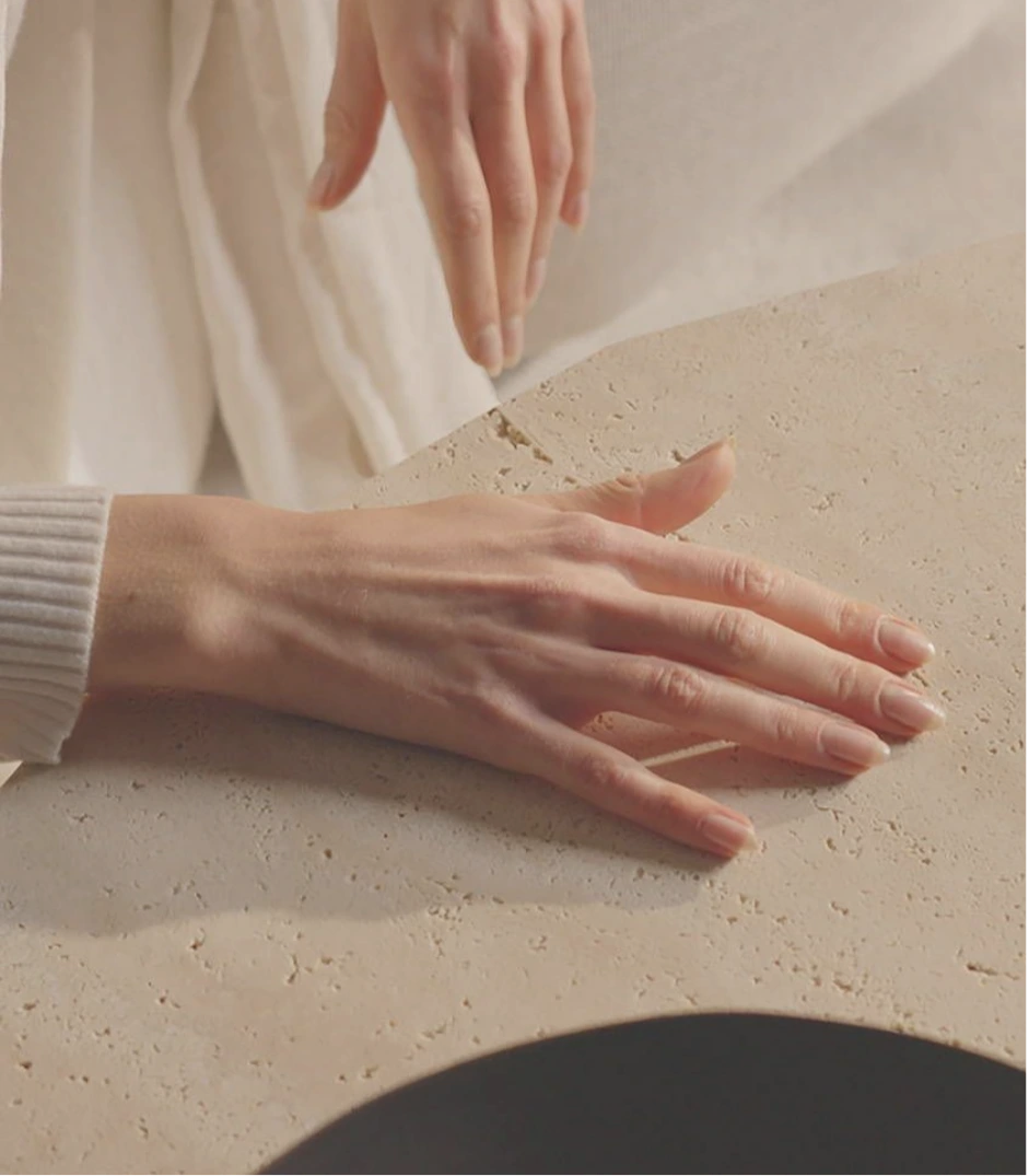 Hands working with natural stone in warm daylight